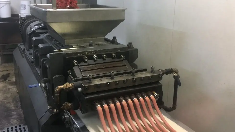 Lange lakridsstrenge presses ud i en fabrik